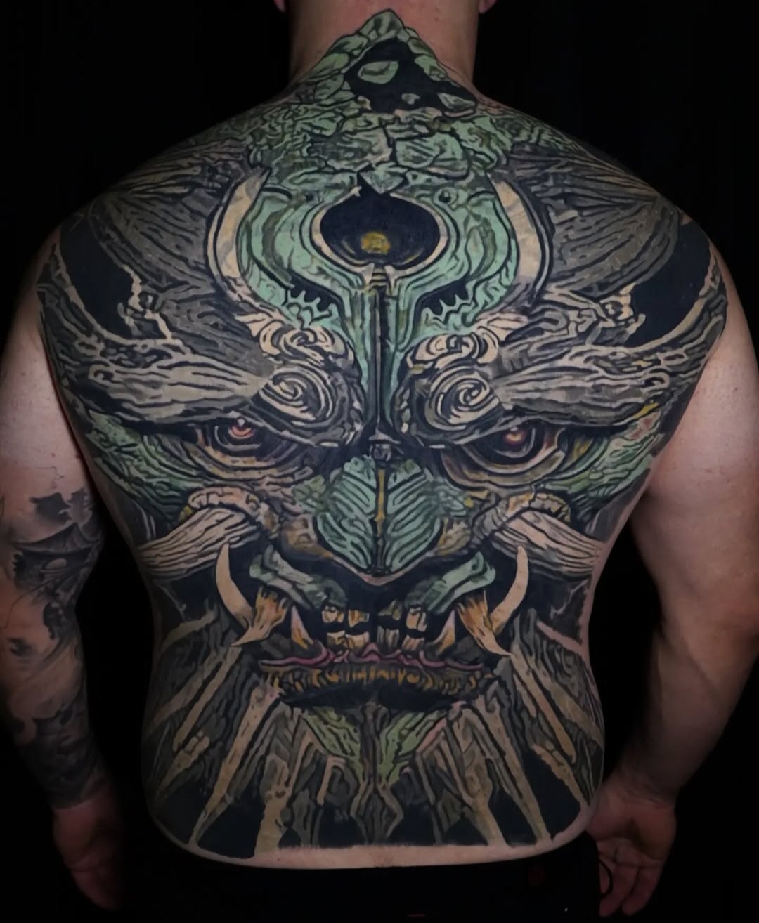 Ornate Japanese-inspired mask back piece tattoo by Mattlock Lopes at Inkcredible Tattoo in Virginia Beach